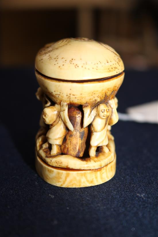 A carved ivory of figures under a crab